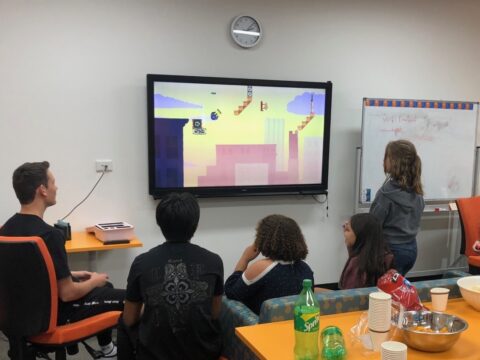 kids playing video games together in classroom