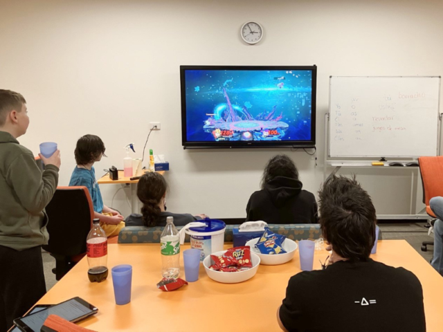 snacks and kids in front of large screen playing video games
